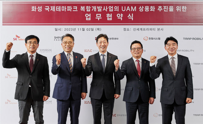 2일 서울 강남구 신세계프라퍼티 본사에서 신용식(왼쪽부터) SK텔레콤 부사장·임영록 신세계프라퍼티 대표·윤형중 한국공항공사 사장·어성철 한화시스템 대표·이종호 티맵모빌리티 대사가 화성국제테마파크 도심항공교통(UAM) 사업 추진을 위한 업무협약(MOU)을 체결 후 기념촬영을 하고 있다. [SK텔레콤 제공]
