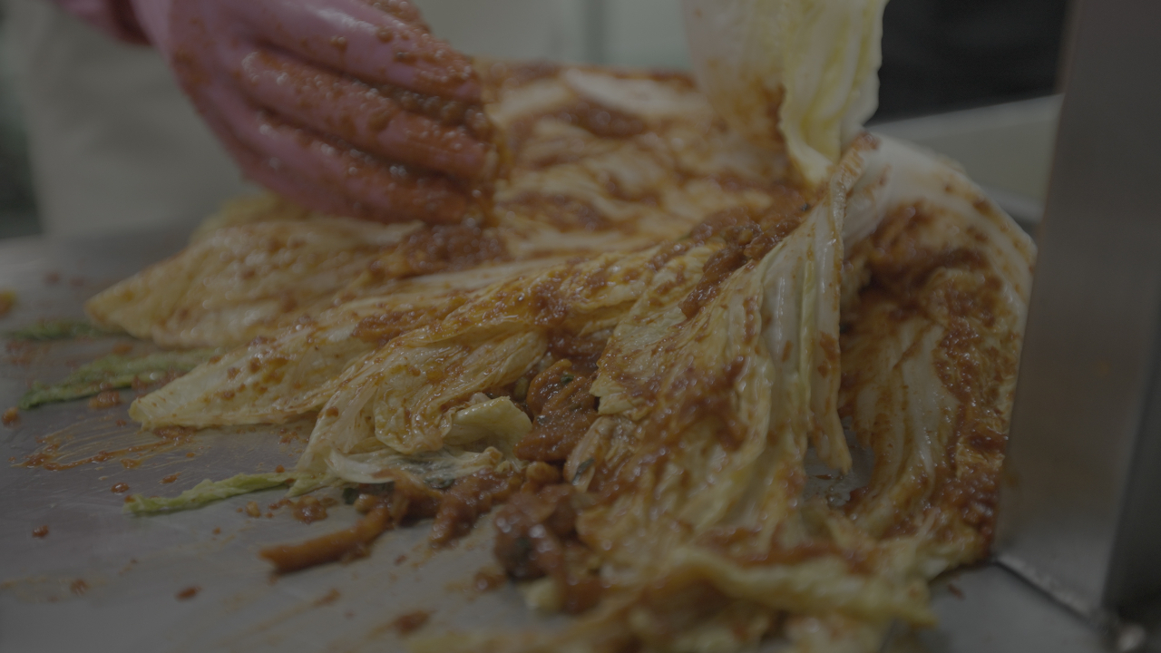 A participant spreads seasonings over cabbage leaves. (Dongwon F&B)