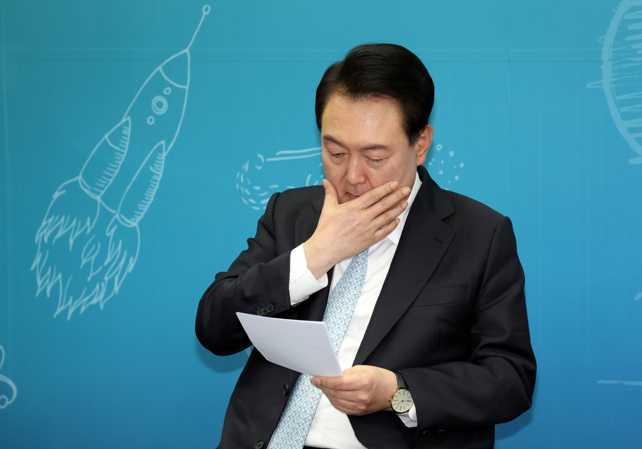 윤석열 대통령이 지난 2일 대전시 유성구 한국표준과학연구원에서 열린 글로벌 우수 신진 연구자들과 대화에서 자료를 살펴보고 있다. [연합]