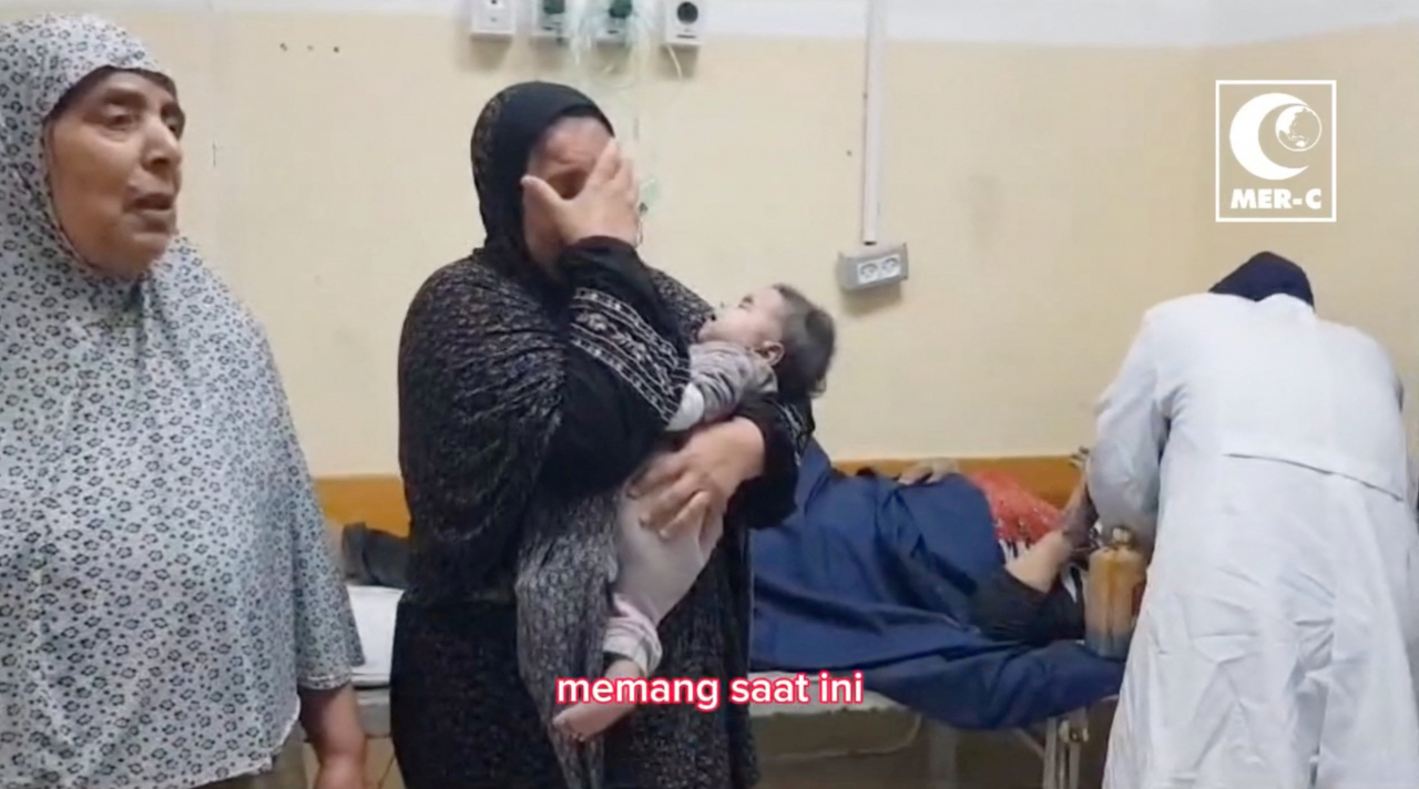 1일(현지시간) 가자지구 북부 베이트 라히아에 있는 병원에서 한 여성이 자신의 아이를 안고 슬퍼하고 있다. 이스라엘의 봉쇄 조치로 연료 부족이 심화하는 가운데 2일 베이트 라히아의 인도네시아 병원에서 발전기가 멈춰 섰다. [소셜 미디어 영상 캡처]