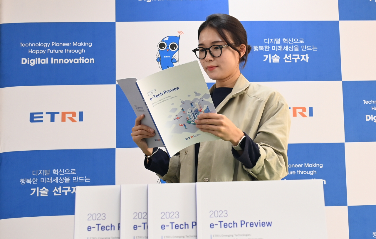 ETRI 연구진이 ETRI가 발간한 2023 이-테크 프리뷰를 읽고 있다.[ETRI 제공]