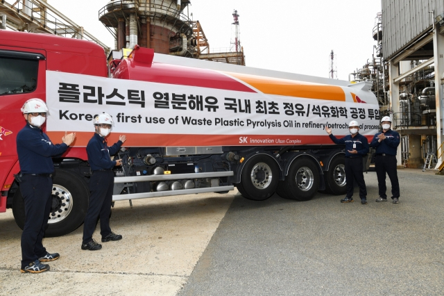 SK이노베이션 울산CLX 구성원들이 공정 투입을 위해 열분해유를 싣고 온 차량 앞에서 기념사진을 촬영하고 있다. [SK이노베이션 제공]