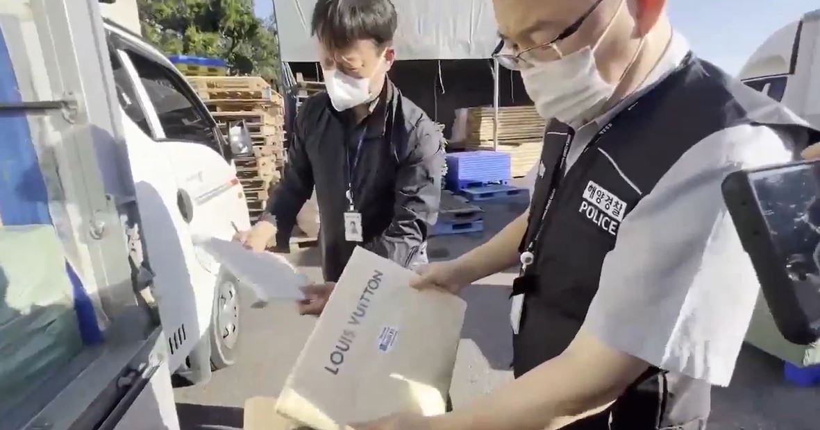 환전물류 바꿔치기 수법으로 반입된 가짜 명품 제품을 확인하는 해양경찰 [인천해경 제공]