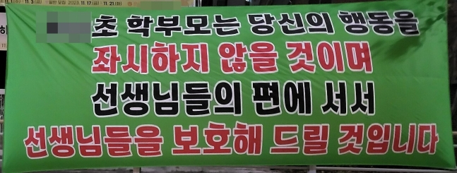 지난 6일 극단선택을 한 대전의 한 초등학교 교사에게 악성 민원을 제기했다는 의혹을 받는 학부모가 이사한 지역에 내걸린 현수막. [온라인 커뮤니티 캡처]