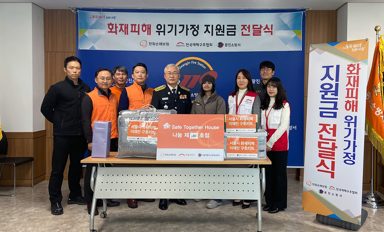 한화손해보험 봉사단이 장형순(가운데) 광진소방서장과 함께 7일 서울시 화재피해가정에 위로금과 구호키트를 전달하고 있다. [한화손해보험 제공]