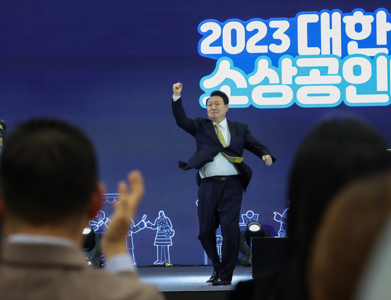 President Yoon Suk Yeol makes his signature uppercut gesture as he attends the opening ceremony to mark this year's convention of small business owners and self-employed workers in Goyang, northwest of Seoul, on Friday. (Yonhap)