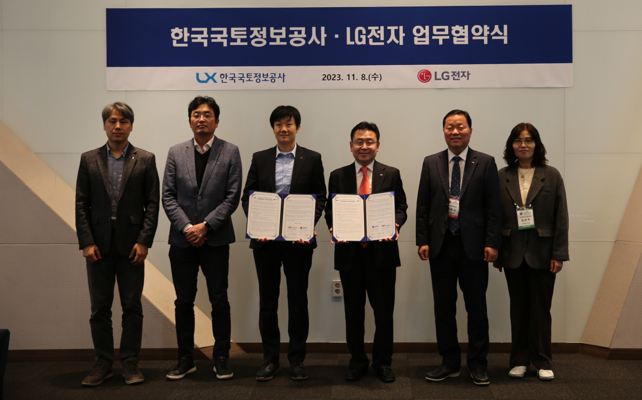 최송욱 LX공사 공간정보본부장(오른쪽에서 세 번째), 백승민 LG전자 로봇선행연구소장(왼쪽에서 세번째) 등 관계자들이 8일 일산 킨텍스에서 로봇 배송 기술 협력을 위한 업무협약을 체결하고 기념 촬영을 하고 있다. [LX한국국토정보공사]