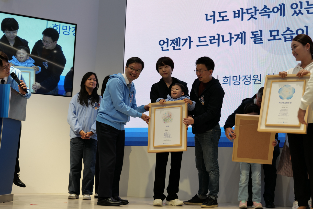 김영태 서울대병원 병원장이 '희망정원' 행사에서 환우가족에게 액자를 전달하고있다.