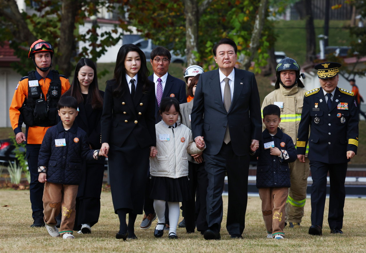 윤석열 대통령과 김건희 여사가 9일 서울 용산어린이정원 잔디마당에서 열린 제61주년 소방의 날 기념식에 순직 소방관 자녀들의 손을 잡고 입장하고 있다. [연합]