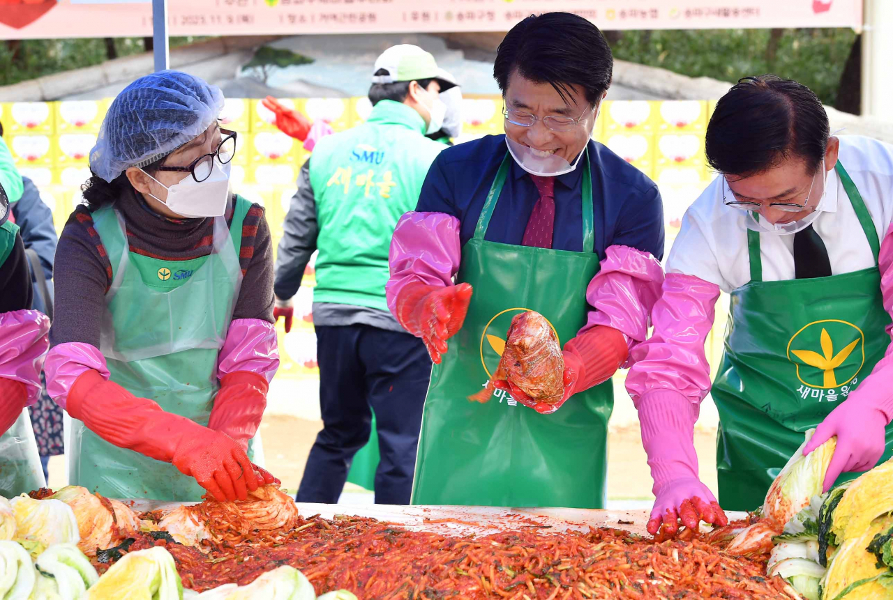 서강석 송파구청장과 새마을부녀회 회원들이 9일 오전 거여근린공원에서 절인 배추에 속을 넣고 있다.[송파구 제공]