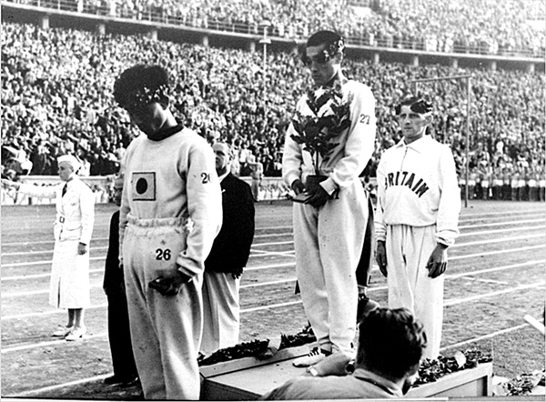 1936년 베를린올림픽 마라톤 대회에서 일장기를 달고 출전해 금메달을 딴 손기정 선수와 3위(동메달)에 오른 조선인 남승룡 선수가 시상대에서 고개를 떨구고 있다. 손기정(27번)은 금메달리스트에만 주어지는 월계수 화분으로 가슴에 새겨진 일장기를 가렸지만, 화분이 주어지지 않아 일장기를 가릴 수 없었던 남승룡(26번) 선수는 나라 잃은 설움이 복받쳤는지 하염없이 고개를 떨구고 있다. [남승룡마라톤 조직위원회 제공]
