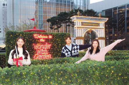 모델이 롯데월드타워 월드파크(야외 잔디광장)에 설치된 크리스마스 정원 ‘원더 위시 가든(The Wonder Wish Garden)’에서 포즈를 취하고 있다. [롯데물산 제공]