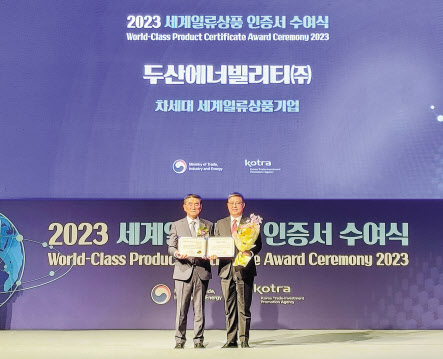 신동규(오른쪽) 두산에너빌리티 풍력/서비스설계 담당 상무와 전춘우 KOTRA(대한무역투자진흥공사) 중소중견기업본부장이 9일 그랜드 인터컨티넨탈 서울 파르나스에서 열린 ‘2023 세계일류상품 인증서 수여식’에서 기념촬영을 하고 있다. [두산에너빌리티 제공]