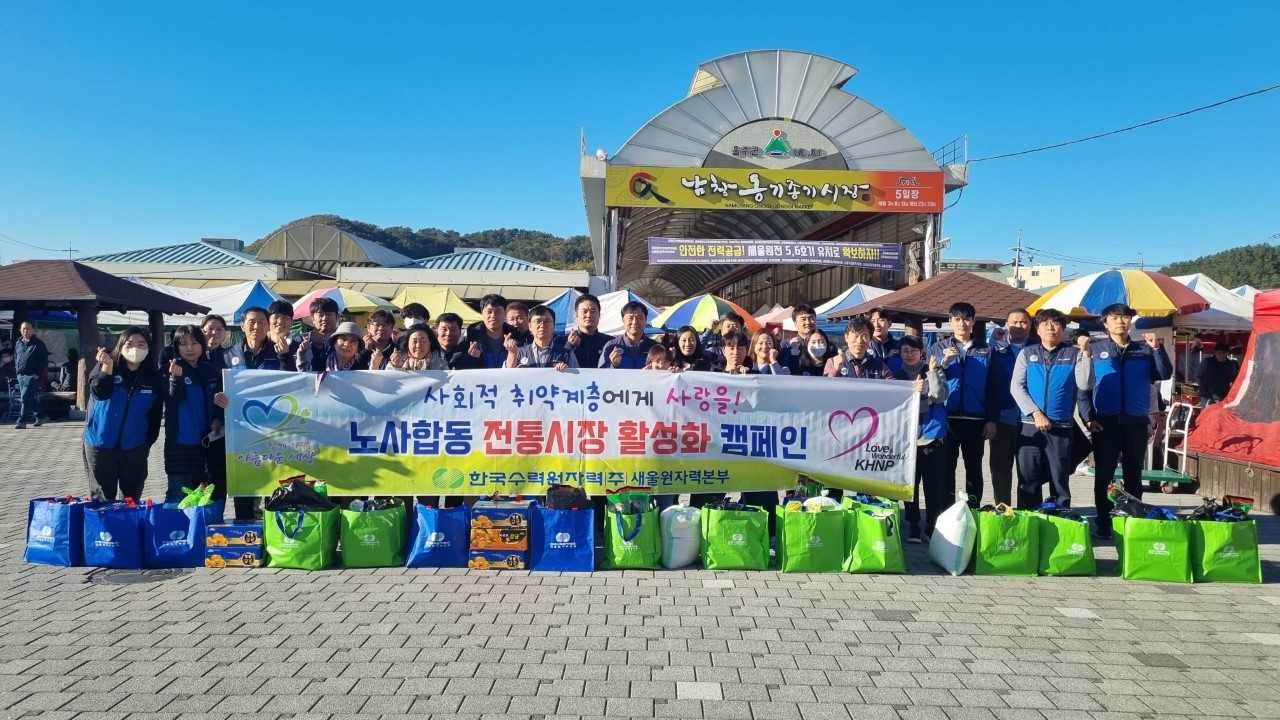 13일 울주군 남창 옹기종기 전통시장에서 진행된 한국수력원자력 새울원자력본부 노사의 전통시장 장보기 행사에서 참가자들이 기념촬영 하고 있다. [사진=새울원자력본부]