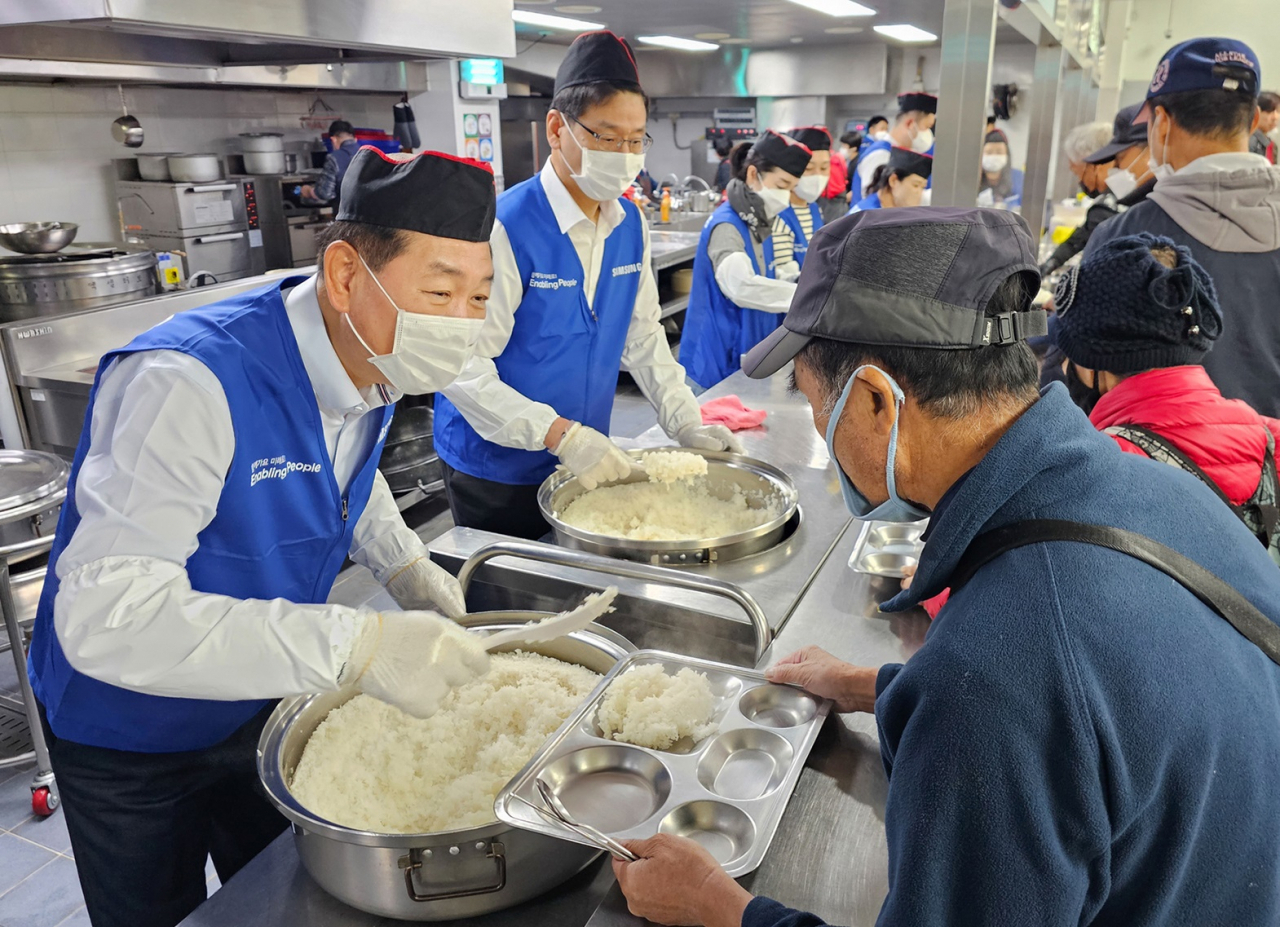 한종희(왼쪽) 삼성전자 부회장 등 삼성전자 임직원들이 지난 6일 경기 성남시 사회복지 기관 '안나의 집'에서 노숙자 대상 배식 봉사에 참여하고 있다.[삼성전자 제공]