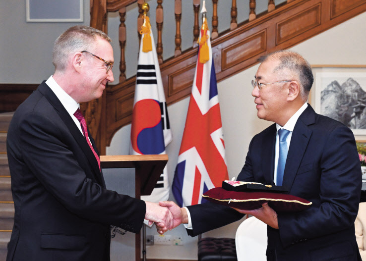 정의선(오른쪽) 현대차그룹 회장이 14일 주한 영국 대사관에서 콜린 크룩스 주한 영국 대사로부터 대영제국 지휘관 훈장을 수훈하고 있다. [현대차 제공]