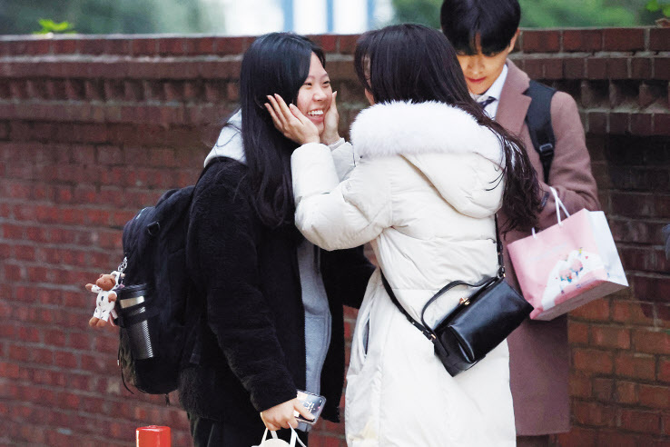 수능일인 16일 오전 광주 북구 경신여고 앞에서 응원을 나온 교사가 수험생 제자를 격려하고 있다.  [연합]