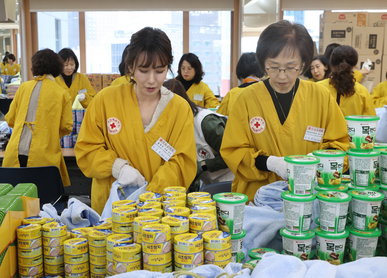 15일 서울 중구 대한적십자사 서울사무소에서 열린 연말 이웃 돕기 적십자 '2023 사랑의 선물' 제작 행사에서 한동훈 법무부 장관의 부인 진은정 변호사(왼쪽) 등 국무위원 부인들이 선물을 포장하고 있다.[연합]