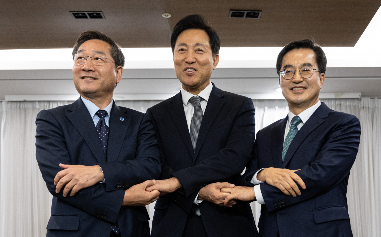 유정복 인천시장(왼쪽부터), 오세훈 서울시장, 김동연 경기도지사가 16일 서울 중구 프레스센터에서 열린 김포시의 서울 편입을 논의하기 위한 3자 회동에서 손을 잡고 기념 촬영하고 있다. [연합]