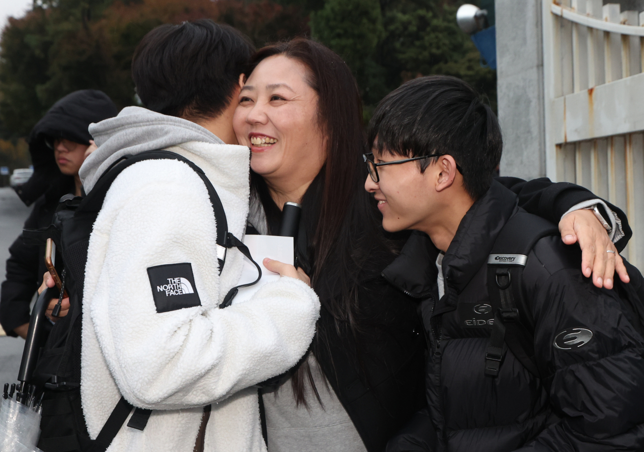 2024학년도 대학수학능력시험일인 16일 오후 서울 용산구 용산고등학교에서 시험을 마친 수험생들이 엄마와 포옹하고 있다. [연합]