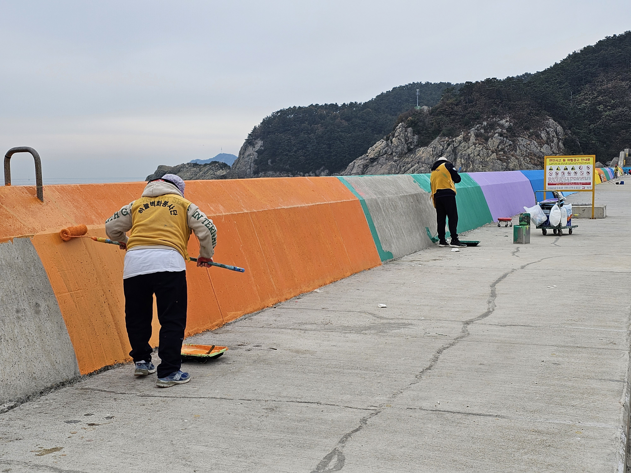 부산항만공사 관계자들이 하늘벽화봉사단과 함께 감천항 서방파제 채색 봉사를 하고 있다. [사진=BPA]
