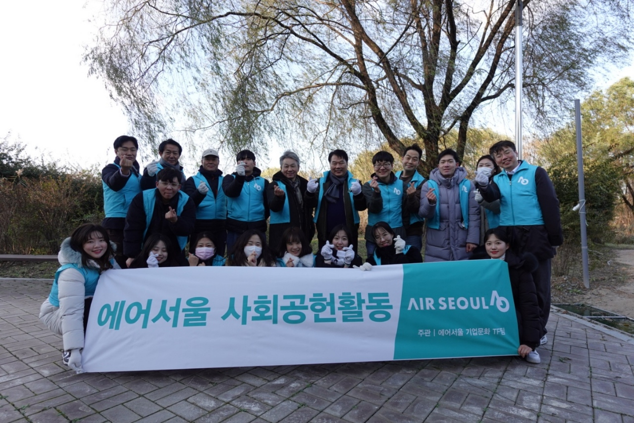 조진만(윗줄 가운데, 왼쪽 6번째) 에어서울 대표이사와 임직원들이 지난 17일 서울시 강서 한강공원에서 진행된 '플로깅' 봉사활동 후 기념 촬영을 하고 있다. [에어서울 제공]
