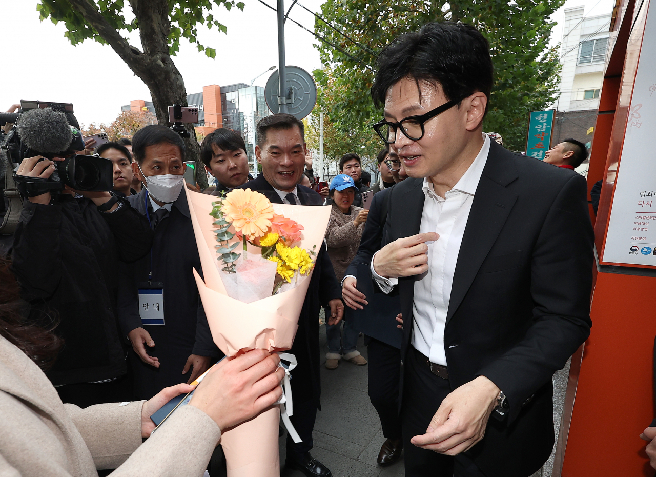 한동훈 법무부 장관이 17일 대구 수성구 스마일센터 방문 중 한 시민에게 꽃다발을 받고 있다. [연합]