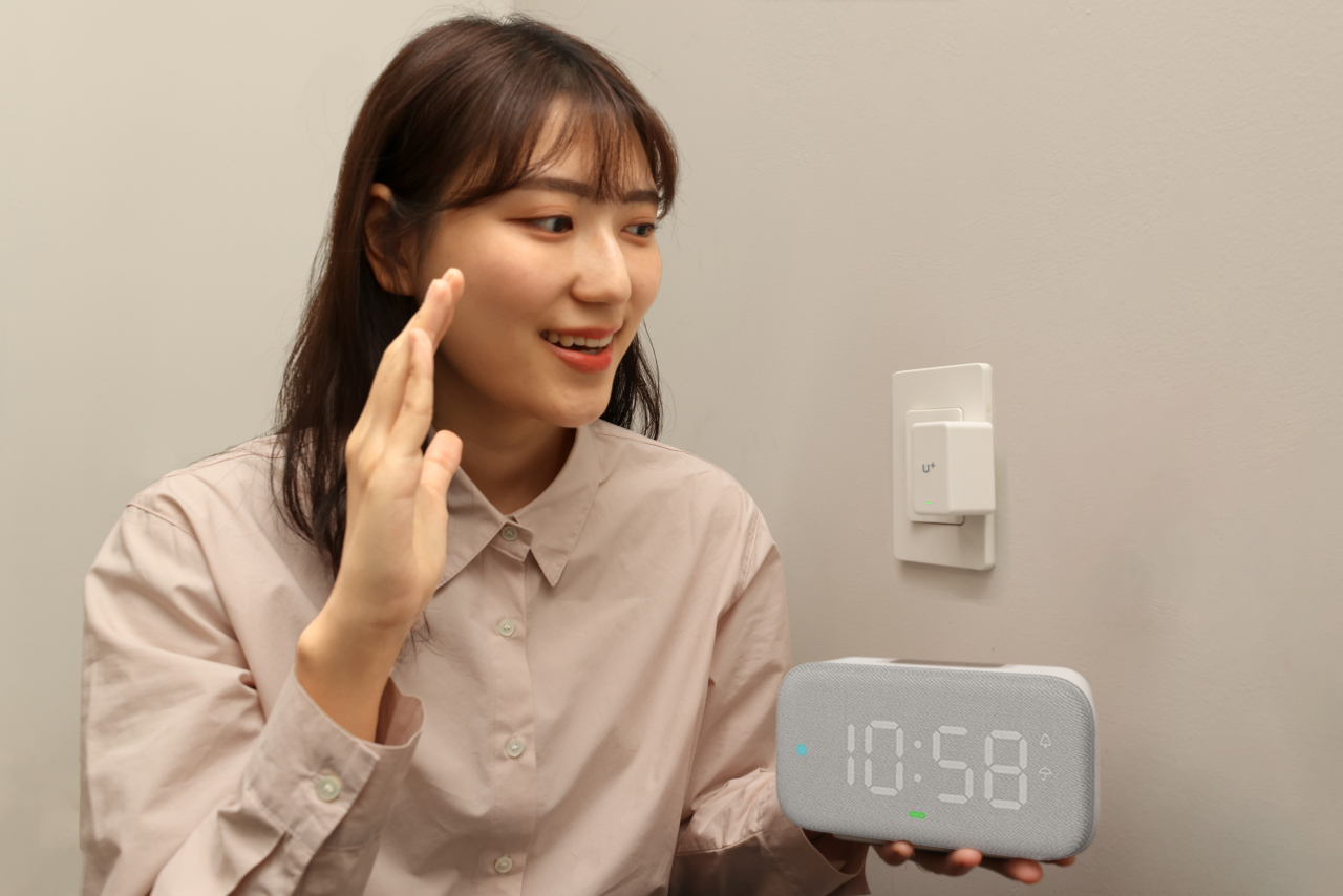 LG유플러스가 집안 조명과 히터 등 가전제품을 원격으로 제어할 수 있는 ‘U+스마트홈 버튼봇’을 출시했다. 사진은 LG유플러스 직원이 조명스위치에 장착된 ‘버튼봇’을 음성으로 제어하고 있는 모습. [LG유플러스 제공]