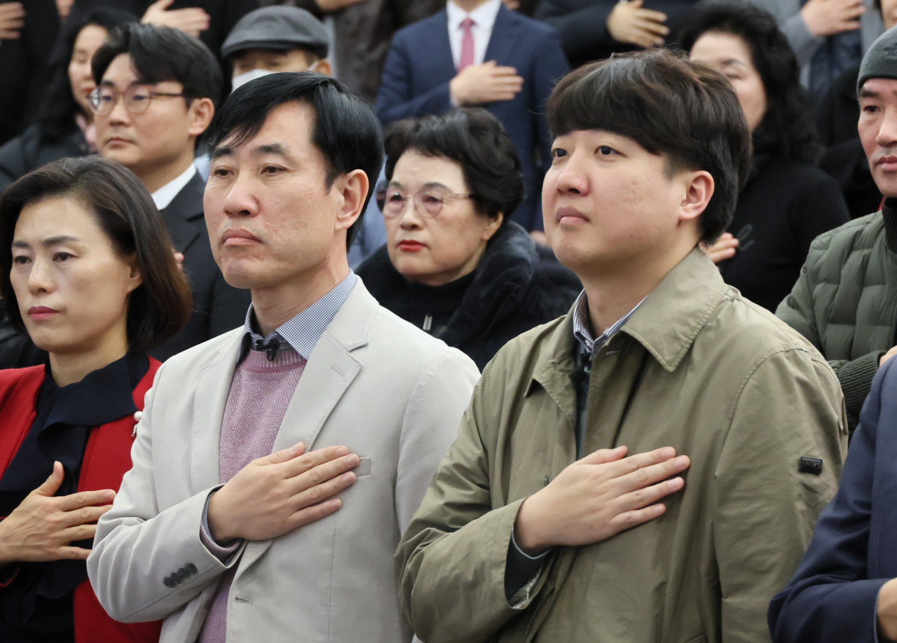 이준석 전 국민의힘 대표(오른쪽)가 20일 국회 도서관에서 열린 하태경 의원의 출판기념회에서 국기에 경례하고 있다. [연합]