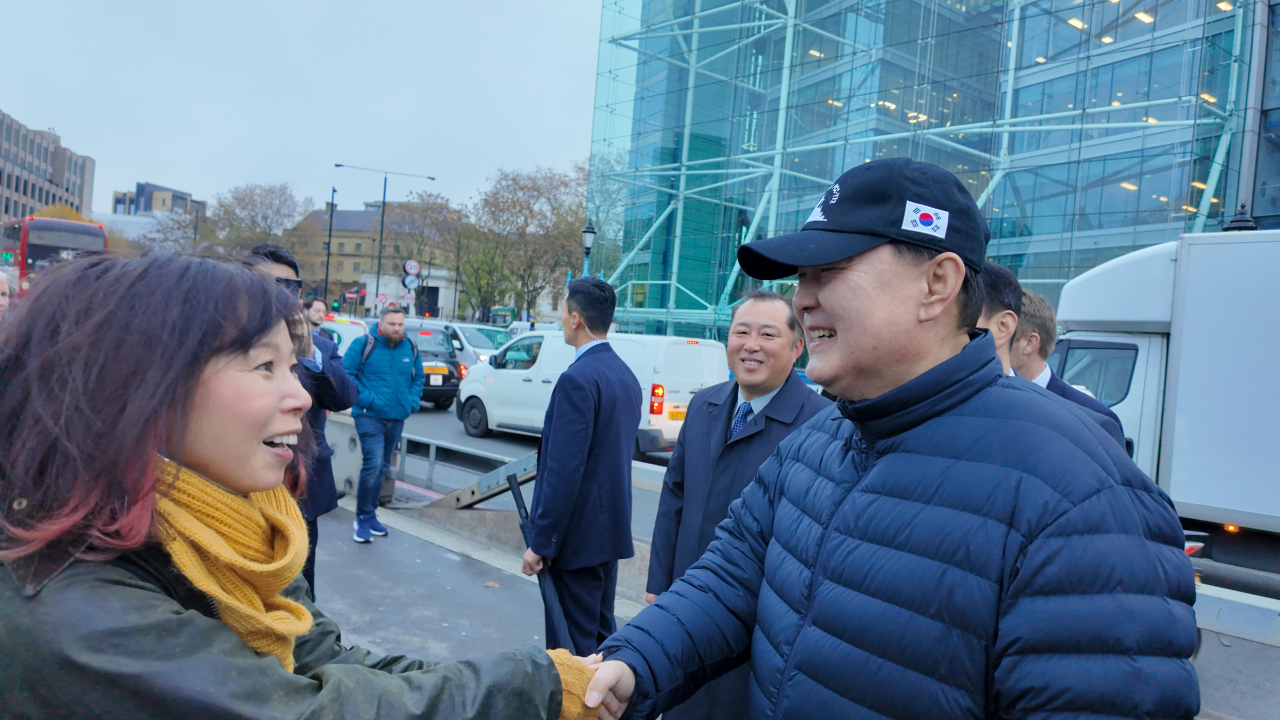 영국을 국빈 방문 중인 윤석열 대통령이 21일(현지시간) 런던 시내를 산책하던 중 다가온 일본인과 인사하고 있다. [연합]