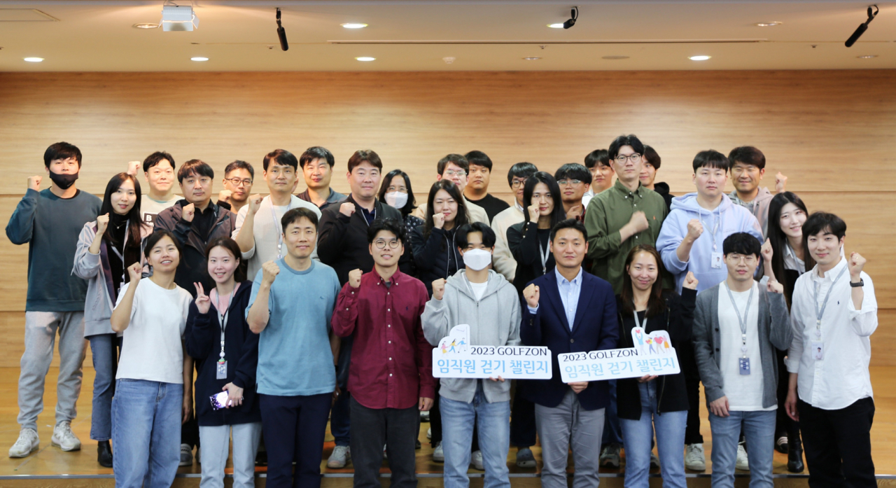 Golfzon employees who participated in the 2023 Golfzon walking challenge at work pose for a photo after receiving gifts at the company's headquarters in Seoul, Oct. 27. (Golfzon)