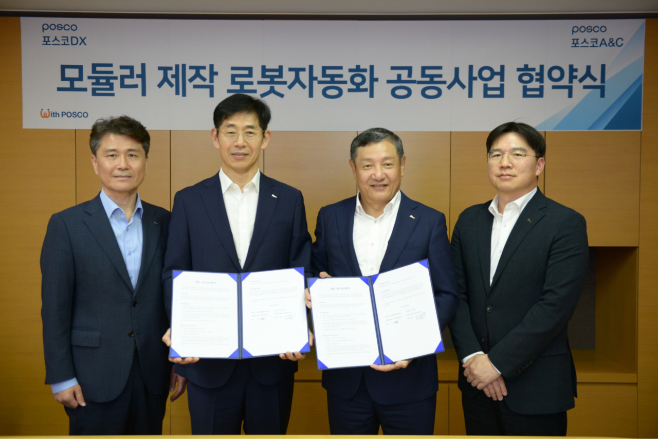정덕균(오른쪽에서 두 번째) 포스코DX 사장과 정훈(왼쪽 두 번째) 포스코A&C 사장을 비롯한 관계자들이 포스코DX 판교 사옥에서 모듈러 제작 로봇자동화 공동 사업을 위한 협약서에 사인하고 기념 촬영을 하고 있다. [포스코DX 제공]