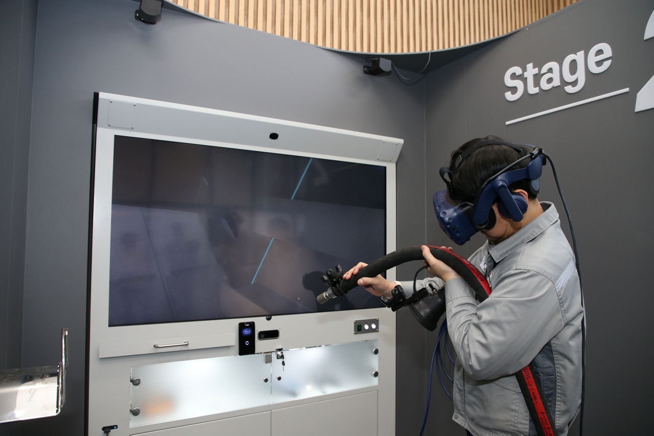 한화오션 거제사업장에 있는 VR(가상현실) 도장교육센터에서 새롭게 개발된 리얼블라스트(RealBLAST)를 통해 VR 블라스팅 직무훈련이 진행되고 있다. [한화오션 제공]