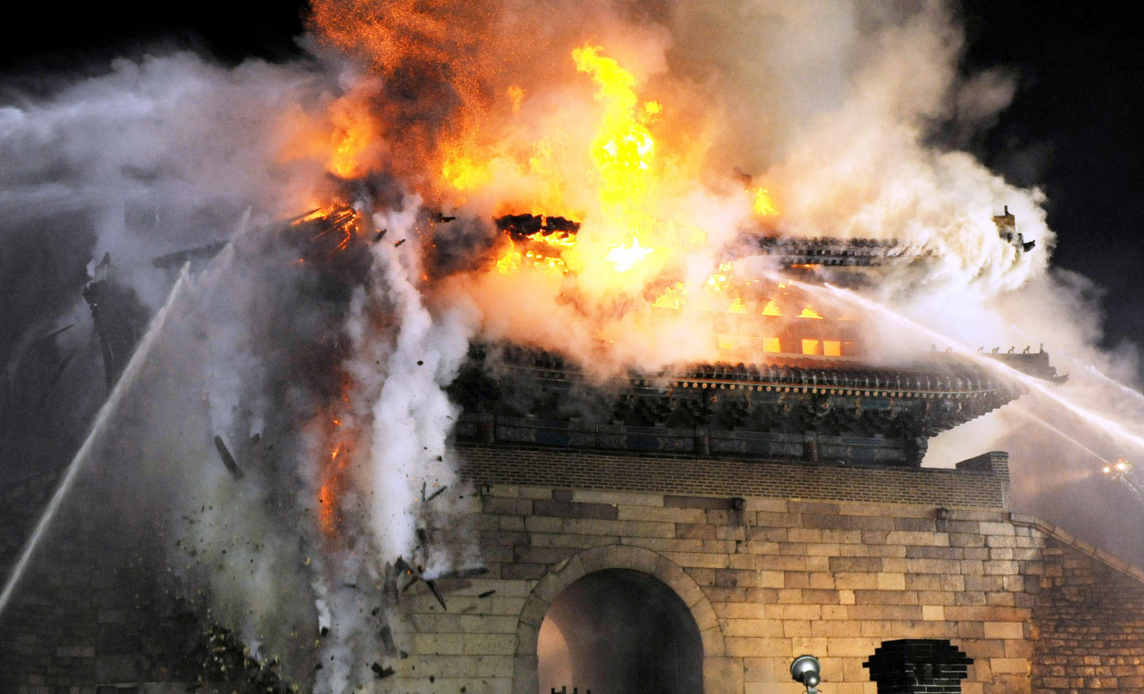 Firefighters try to extinguish the fire on Sungnyemun on Feb. 10, 2008. (The Korea Herald)