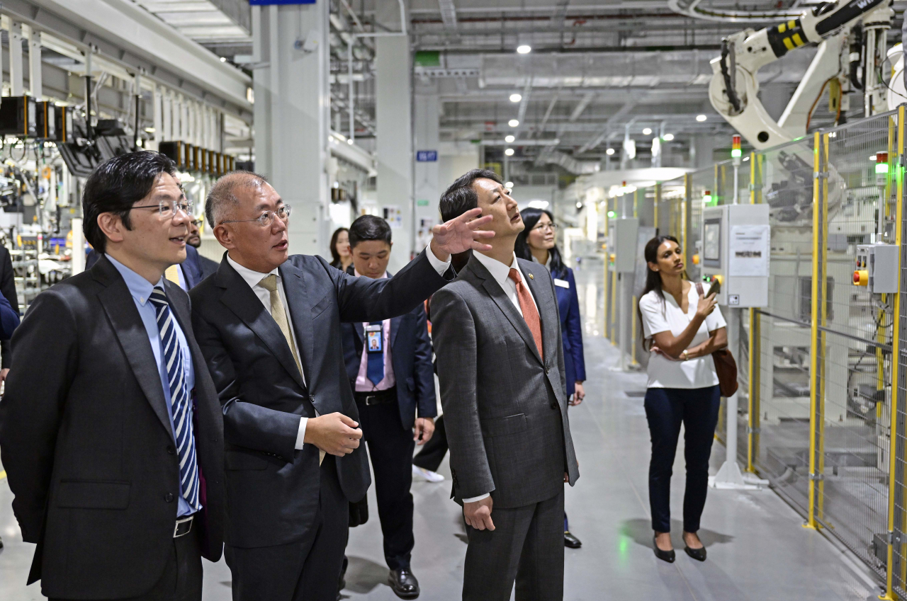 (From left) Singapore Deputy Prime Minster Lawrence Wong, Hyundai Motor Group Executive Chair Chung Euisun and South Korean Trade Minister Ahn Duk-geun tour the Hyundai Motor Group Innovation Center Singapore on Tuesday. (Hyundai Motor Group)