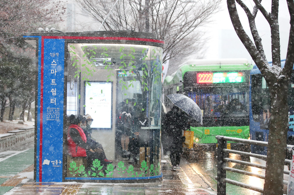 눈이 내리고 있는 가운데 성동구 스마트쉼터에서 주민들이 버스를 기다리고 있다. [성동구 제공]