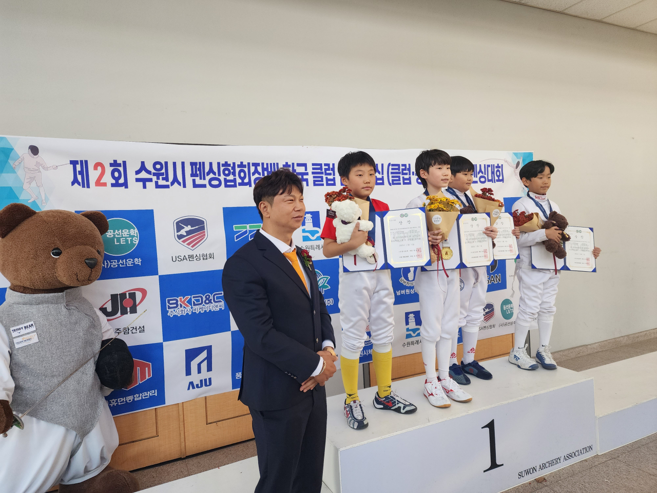 An Jae-cheon(left), president of BK D&C, poses with the top contestants in the elementary school division of the Korea Club Championship &ndash; Fencing, that took place Nov.11-12 in this file photo. (Suwon Fencing Association)