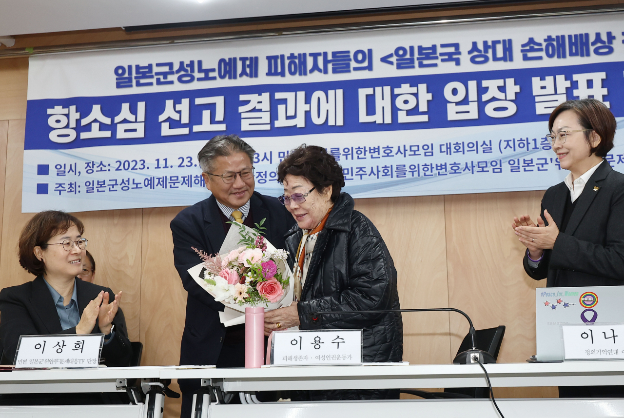 서울고등법원이 일본군 '위안부' 피해자·유족의 일본 정부 상대 손해배상 청구 소송 2심에서 1심의 '각하' 판결을 취소한 23일 오후 서울 서초구 민주사회를위한변호사모임에서 열린 선고 결과 입장 발표 기자회견에서 '위안부' 피해자 이용수 할머니가 꽃다발을 받고 있다. [연합]