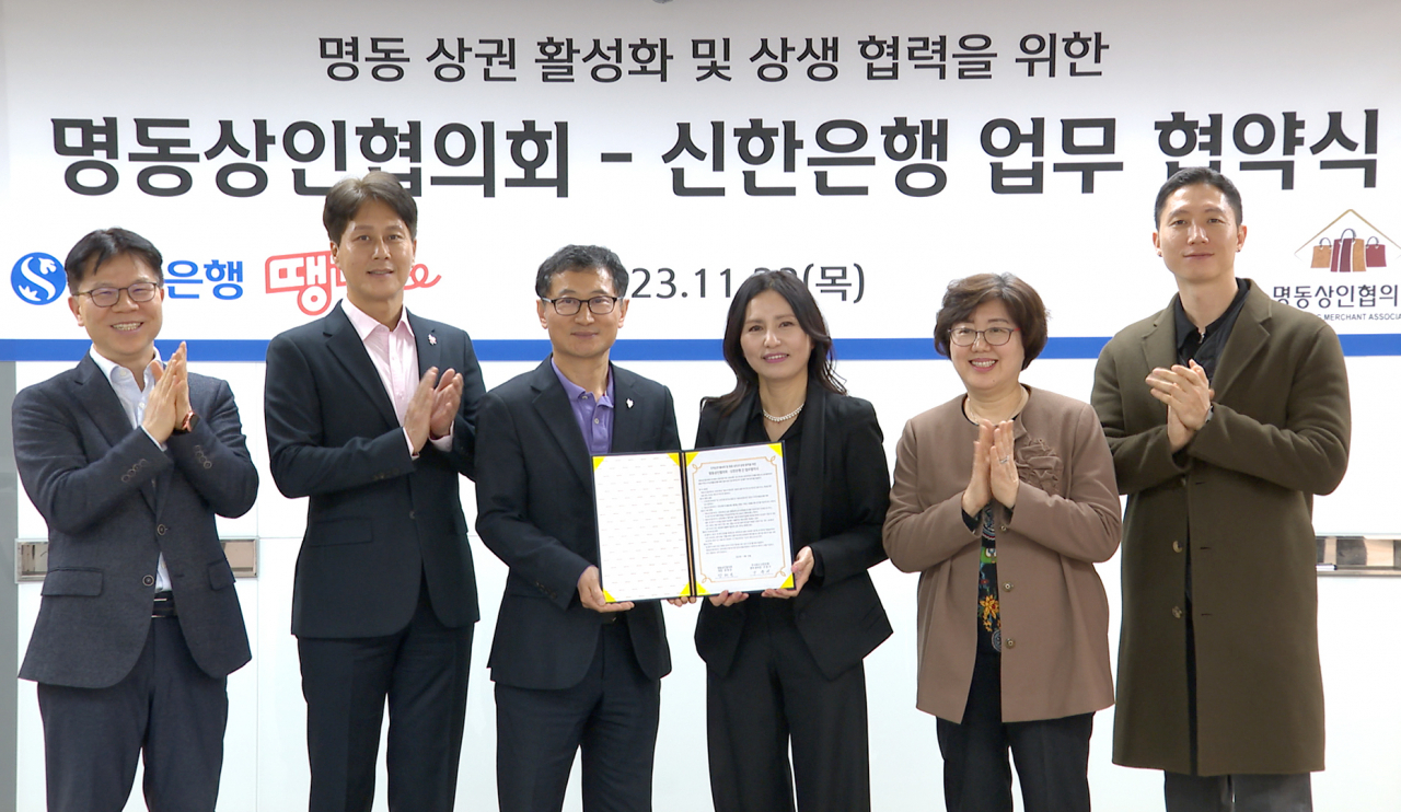 지난 23일 서울시 중구에 위치한 신한은행 명동기업금융센터에서 진행된 ‘명동상인협의회-신한은행 업무협약식’에서 구춘서(왼쪽 세번째) 신한은행 중부본부장과 강태은(왼쪽 네번째) 명동상인협의회 회장이 관계자들과 기념촬영하고 있다.[신한은행 제공]