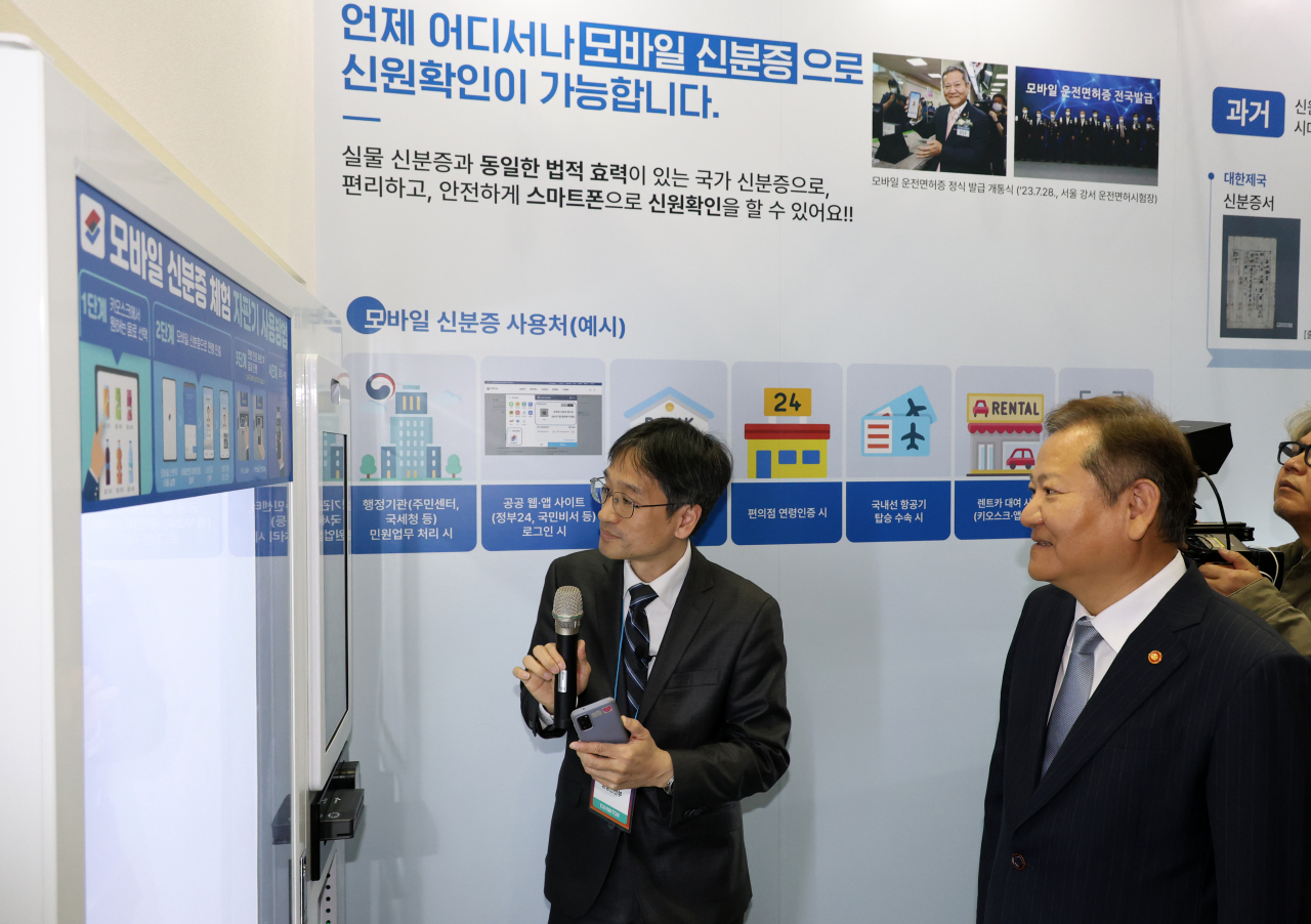 25일 오후 부산 해운대구 벡스코에서 열린 대한민국 정부박람회에서 이상민 행정안전부 장관이 모바일 신분증 활용한 자판기에 대해 설명 듣고 있다. [연합]