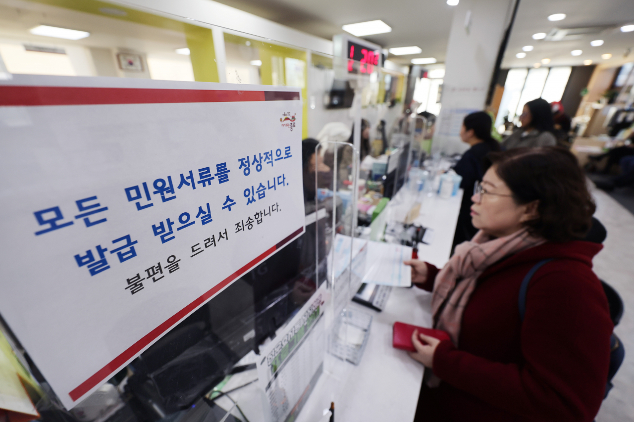 행정안전부가 전국 시군구·읍면동 주민센터에서 민원 서류 발급 서비스를 재가동한다고 알린 20일 오전 서울 종로구 청운효자동주민센터 창구에 민원 서류 정상 발급 안내문이 부착돼 있다.[연합]