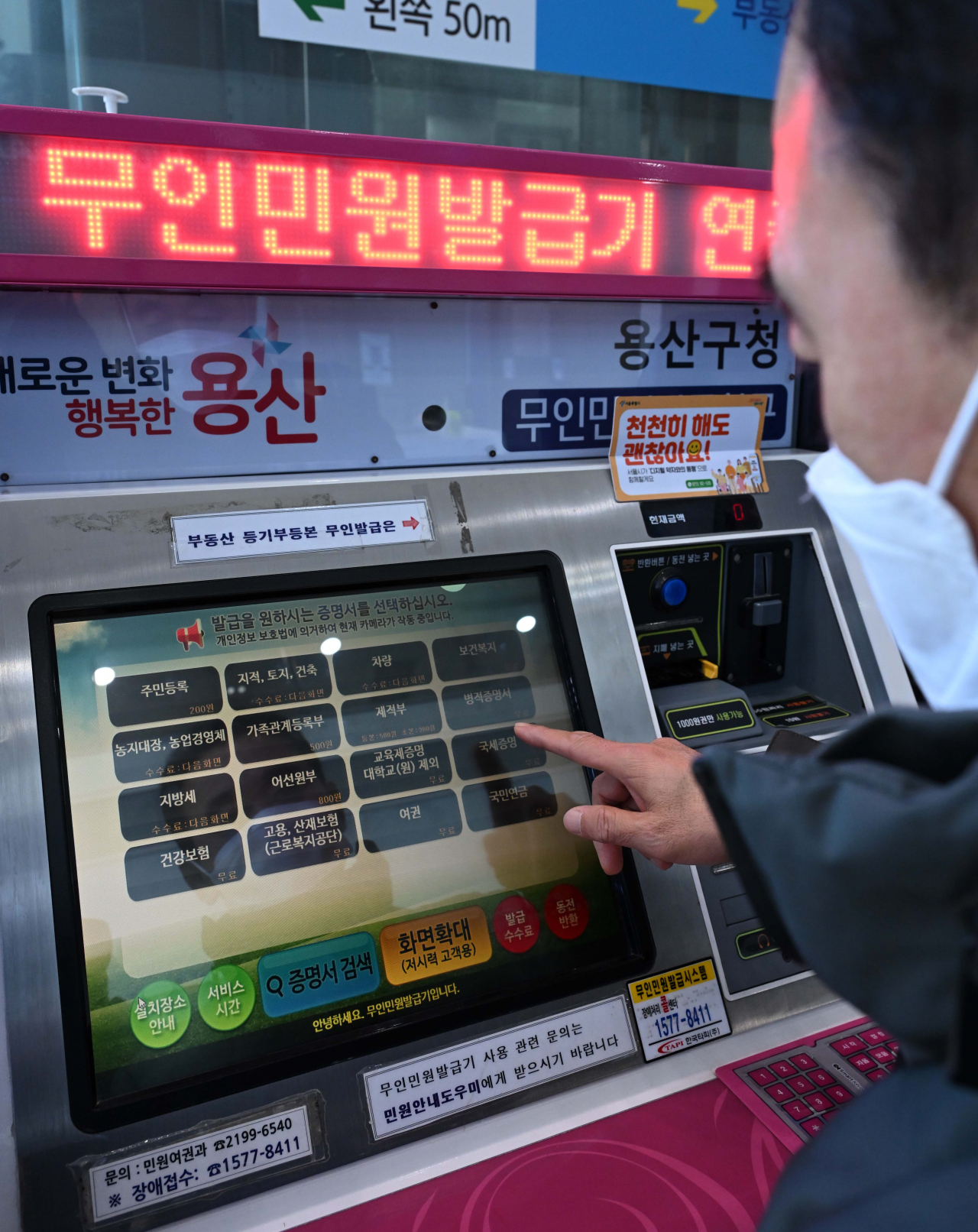 서울 용산구 용산구청 민원실에서 민원인이 무인민원발급기로 서류를 발급받고 있다. [이상섭 기자]