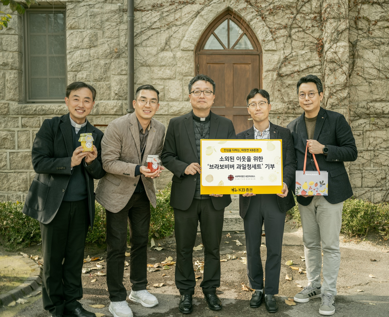 지난 23일 KB증권이 주교좌 의정부 성당(경기도 의정부시) 앞에서 사회복지법인 대건카리타스에 기부물품 전달식을 진행하며 기념사진을 촬영하고 있다. [KB증권]