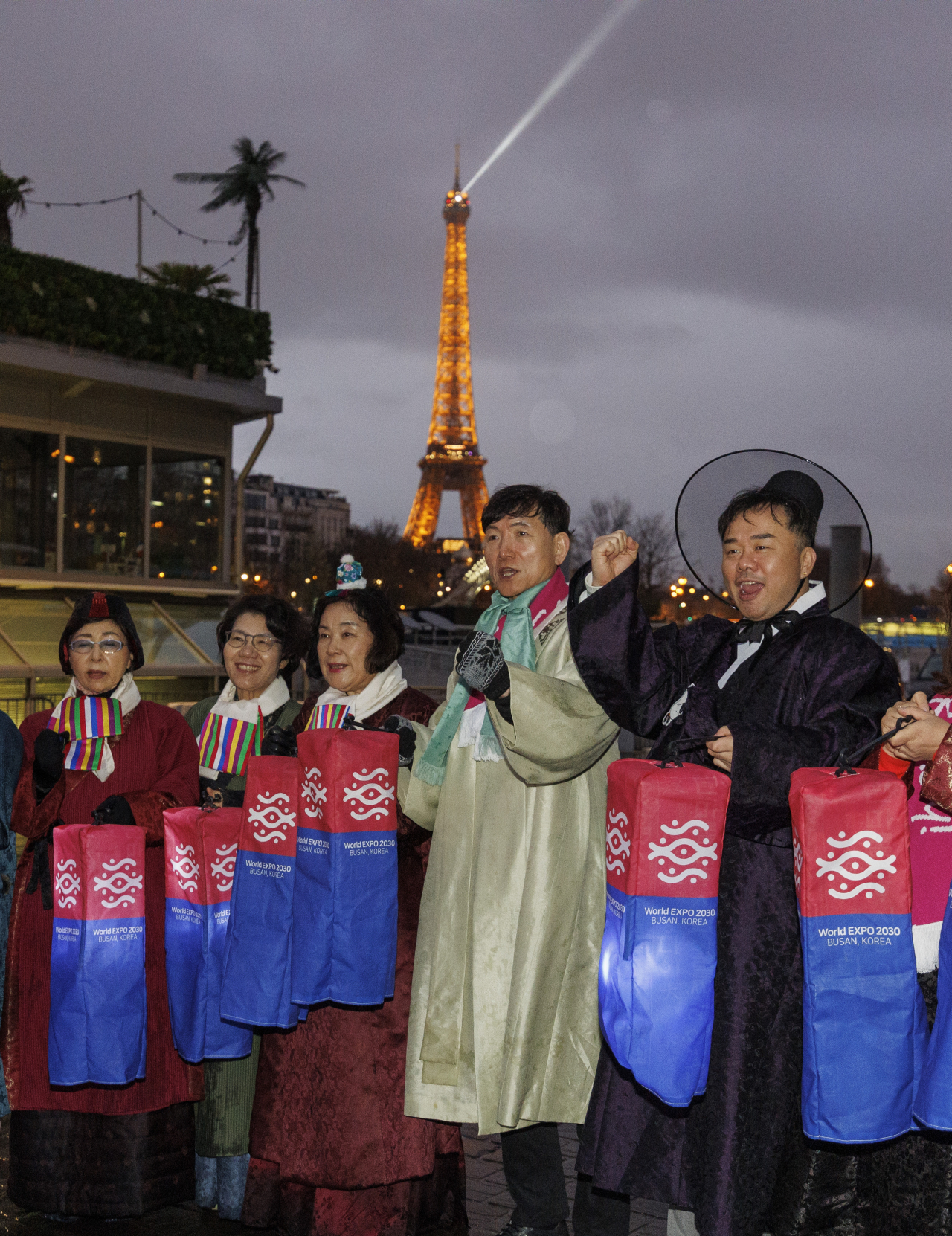 Members of a South Korean civic group hold "cheongsachorong," a traditional Korean lantern with a red-and-blue silk shade, during an event along the Seine River in Paris on Nov. 27, 2023, to promote South Korea's bid to host the 2030 World Expo in the port city of Busan, one day before a Bureau International des Expositions vote to choose the event's host city. (Yonhap)