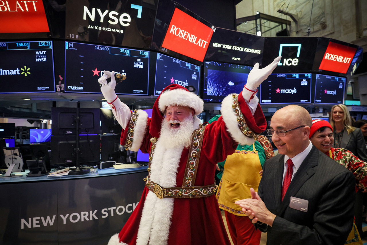 미국 뉴욕증권거래소(NYSE)를 방문한 산타클로스가 '메이시스 추수감사절 퍼레이드'(Macy's Thanksgiving Day Parade)를 기념하고 있다. 연합뉴스
