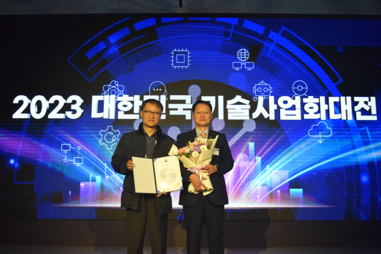 김용진(오른쪽) 저스템 사장, 이광재(왼쪽) 저스템 기술기획팀장이 ‘2023 대한민국 기술사업화대전’에서 기념사진을 촬영하고 있다. [저스템 제공]