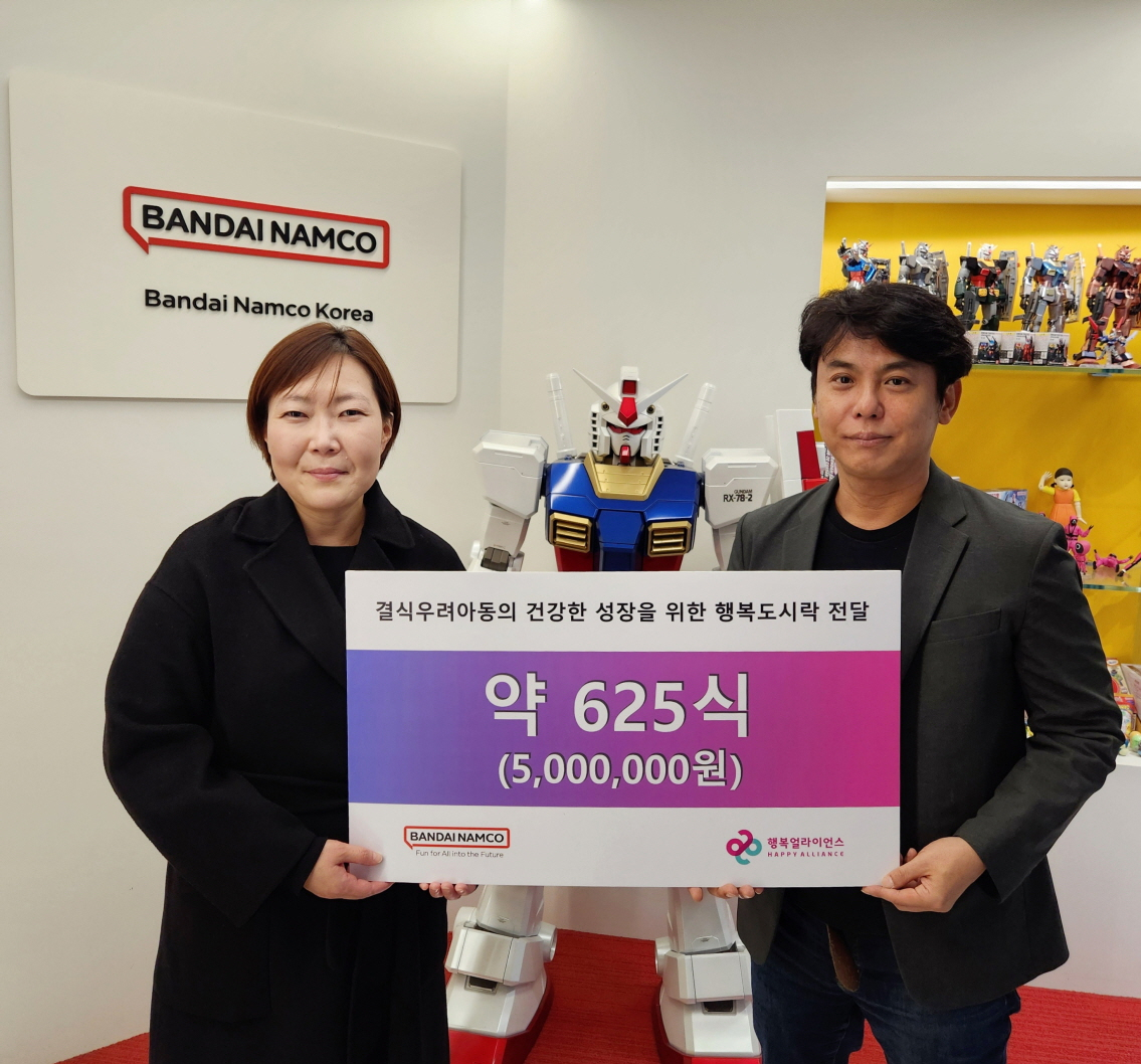 임은미(왼쪽) 행복얼라이언스 사무국 실장, 야마미치 후미아키 반다이남코 코리아 대표가 도시락 전달식을 진행하고 기념 촬영을 하고 있다. [행복얼라이언스 제공]
