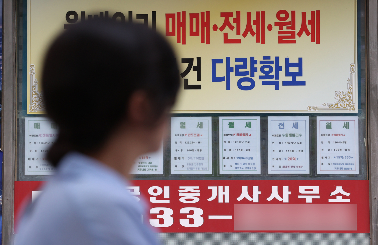 서울 한 부동산중개사무소 앞을 시민이 지나가고 있다.[연합]