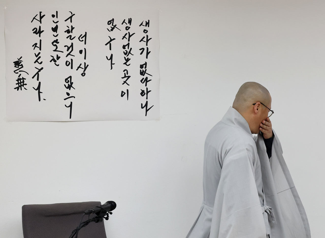 30일 서울 한국불교역사문화기념관에서 대한불교조계종 총무원 기획실장 우봉스님이 전날 경기 안성시 죽산면 칠장사에서 화재로 입적한 자승 스님의 장례와 관련한 언론 브리핑을 하던 중 울먹이며 잠시 자리를 나서고 있다. 왼쪽에 자승스님이 남긴 열반송이 붙어 있다. [연합]
