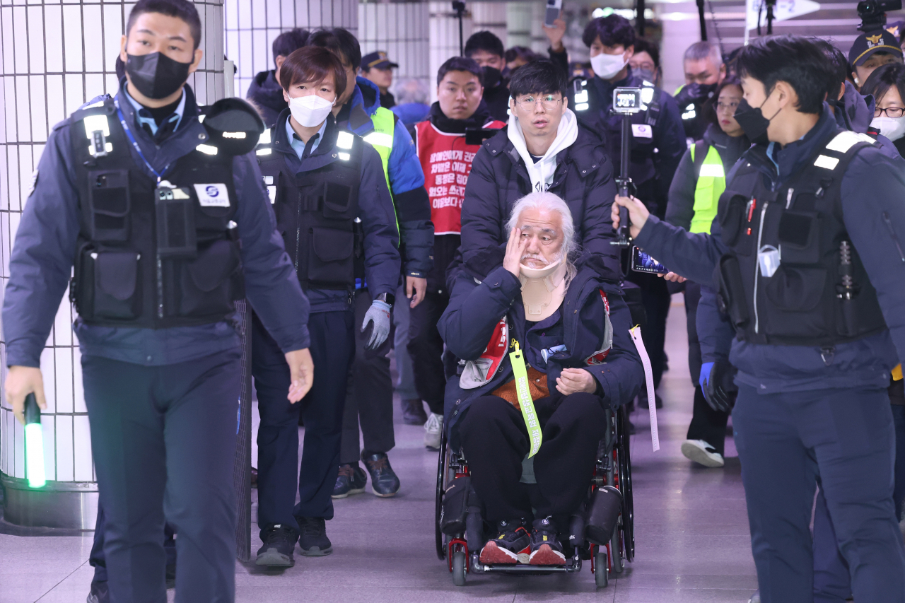박경석 전국장애인차별철폐연대(전장연) 대표가 지난 30일 오후 서울 시청역에서 빠져나가고 있다. 박 대표는 이날 시청역 승강장에서 '서울시 권리중심일자리 연계사업 폐지 규탄 전국결의대회'를 열 예정이었으나 퇴거 요청을 받고 빠져나갔다. [연합]